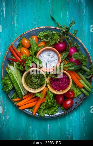 Piatto di verdure crudite con tre diversi salse Foto Stock