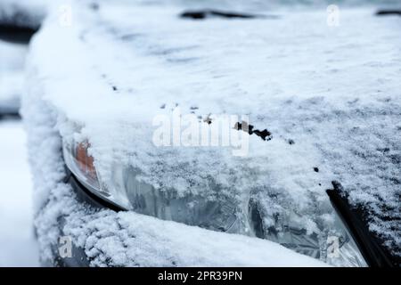 Auto moderna coperta di neve all'aperto il giorno d'inverno, primo piano. Tempo gelido Foto Stock