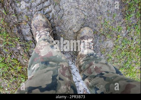 Stivali tattici sporchi del soldato dopo le esercitazioni nel fango. Foto Stock