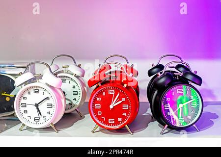 gli orologi di sveglia guardano le luci bianche rosse e nere con illuminazione rosa brillante. Cambiare l'ora in estate o in inverno Foto Stock