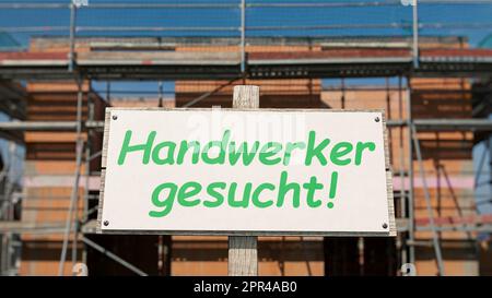 Cartello di fronte alla costruzione della conchiglia con l'iscrizione tedesca: 'Handwerker gesucht' (Craftsman Wanted) Foto Stock