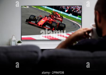 Uomo che guarda le corse in formula sullo smart TV. Trasmissione di corse dal vivo. ROSARIO, ARGENTINA - 4 APRILE 2023 Foto Stock