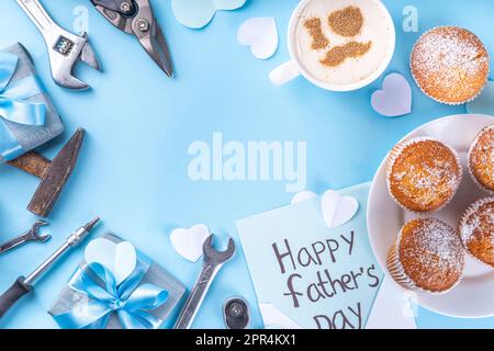 Biglietto di auguri per il giorno del Padre. Colazione del giorno del papà con simpatico sfondo a sorpresa, con confezioni regalo, cupcake, tazza di caffè, decorazione del cuore, Foto Stock