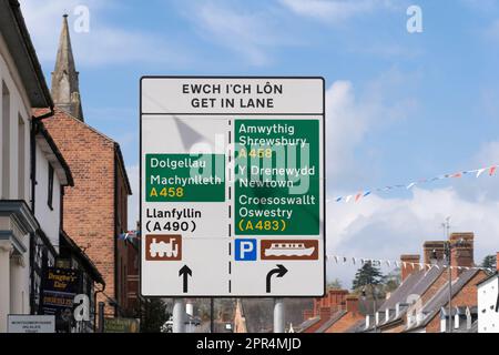 Doppio cartello bilingue inglese e gallese con indicazioni stradali e luoghi di interesse intorno a Welshpool, una città commerciale di Powys, Galles Foto Stock