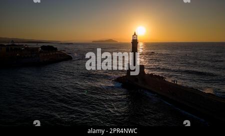 Tramonto dietro un vecchio faro di pietra nella città greca di Chania, Creta Foto Stock