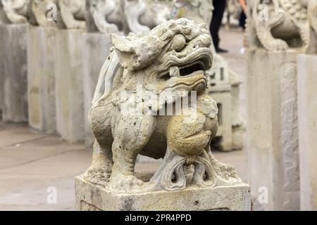 Il leone in stile cinese scolpito sul piedistallo è un animale sacro di credenza cinese. Foto Stock