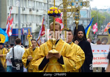 Giovane monaco ortodosso che porta la croce dorata per strada. Chiesa Ucraina Ortodossa del Patriarcato di Kyiv, processione incrociata. Kiev, Ucraina Foto Stock