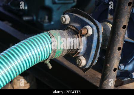 Pompa dell'acqua centrifuga collegata ad un tubo di ingresso con dadi e bulloni per l'alimentazione dell'acqua a scopo di irrigazione Foto Stock