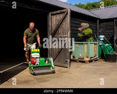 BICESTER, INGHILTERRA - 11 AGOSTO 2021: Paul Gough, capo giardiniere in una proprietà privata in Oxfordshire, con macchinari. Foto Stock