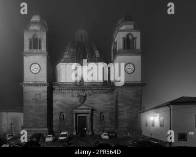 Vista notturna in bianco e nero della Cattedrale di Santa Margherita, Montefiascone, Italia, parzialmente avvolta nella nebbia Foto Stock