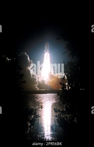 Il fervente liftoff di Space Shuttle Discovery dal Launch Pad 39B sulla missione STS-116 si riflette nelle acque vicine. Il liftoff si è verificato in tempo alle 8:47 Ora standard orientale. Questa era la missione 33rd di Discovery, la prima notte di lancio dal 2002, e la missione navetta 20th per la Stazione spaziale Internazionale. Foto Stock