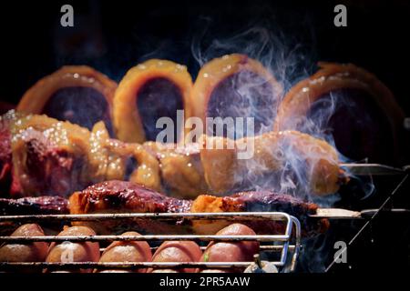 Spiedini di carne sfrigolano sulla brace fumante, emanando un aroma delizioso. Il calore del fuoco li rende succulenti e tenero Foto Stock