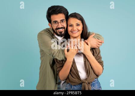 Bella giovane coppia indiana posa su sfondo blu studio Foto Stock