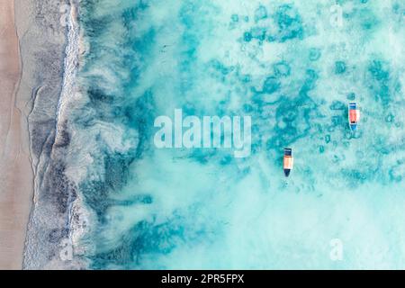 Veduta aerea delle barche nelle acque cristalline dell'Oceano Indiano vicino ad una spiaggia tropicale vuota, Zanzibar, Tanzania Foto Stock