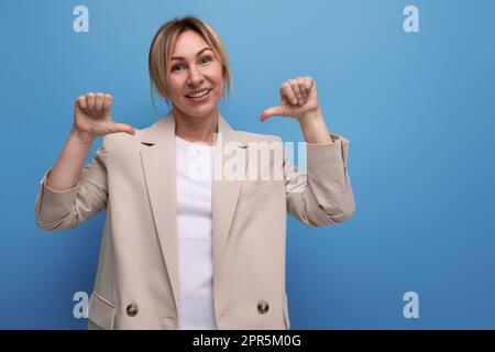 ritratto di una gentile giovane donna d'affari bionda in una giacca sullo sfondo con spazio copia Foto Stock