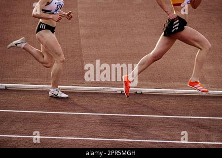 Due runner femminili nei campionati estivi di atletica Nike e Adidas Spikes si allenano a metà distanza allo stadio Foto Stock