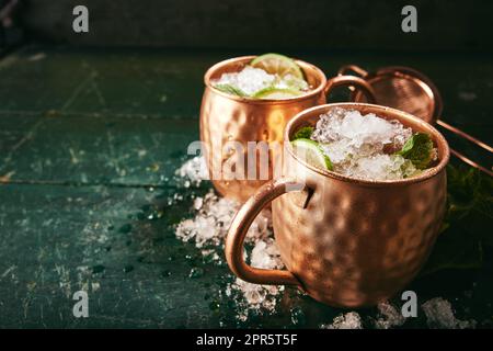 Cocktail di mulo a Mosca in tazze di rame sul tavolo Foto Stock