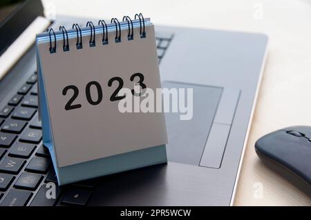 Testo di Capodanno 2023 sulla scrivania del calendario sopra un notebook Foto Stock