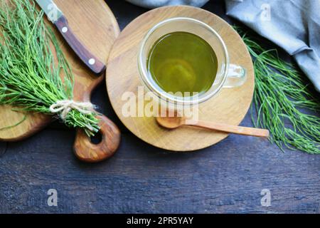 Pianta di Horsetail fresco su un tavolo con tè alle erbe sullo sfondo di legno Foto Stock
