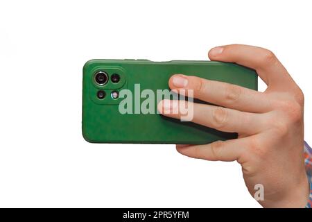 Mano di un uomo in primo piano che tiene un telefono cellulare o uno smartphone in una custodia verde su uno sfondo bianco, isolato. Foto Stock