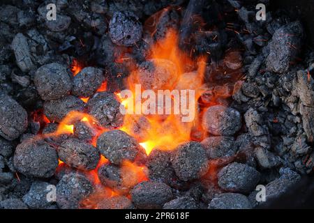 Calore che schiarisce da carbone incandescente per indurire i coltelli Foto Stock