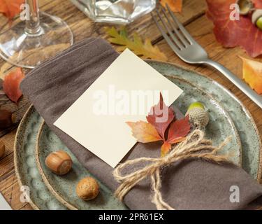 Ambiente da tavola rustico autunnale con cartellino vuoto tra foglie colorate e frutti di bosco da vicino, mockup Foto Stock