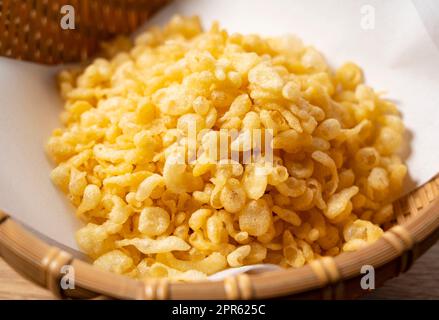 Tenkasu servito in un colander posto su uno sfondo di legno. Foto Stock