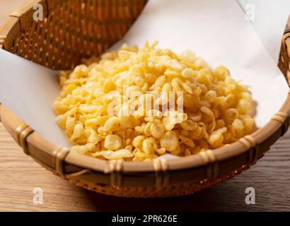 Tenkasu servito in un colander posto su uno sfondo di legno. Foto Stock