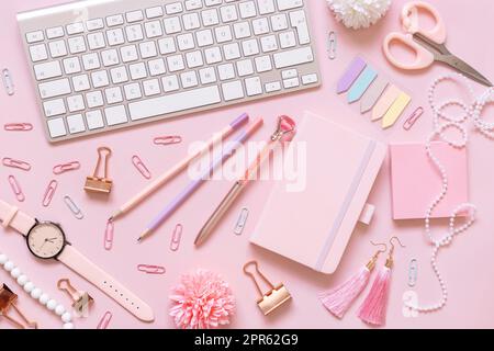 Notebook, accessori rosa scuola girly e tastiera su rosa pastello vista dall'alto, mockup Foto Stock