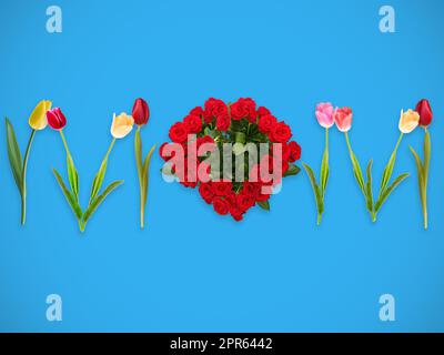 Mamma parola creata da tulipani e bouquet di rose rosse a forma di cuore su sfondo azzurro chiaro Foto Stock