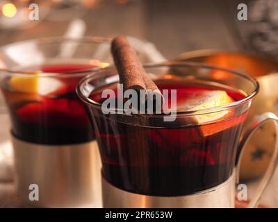 Gustoso VIN brulé con fette di limone e cannella su un rustico tavolo in legno, concetto di cibo di stagione, sfondo natalizio Foto Stock