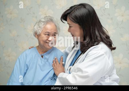 Medico che usa stetoscopio per controllare il paziente sedersi su un letto nel reparto ospedaliero, sano concetto medico forte Foto Stock