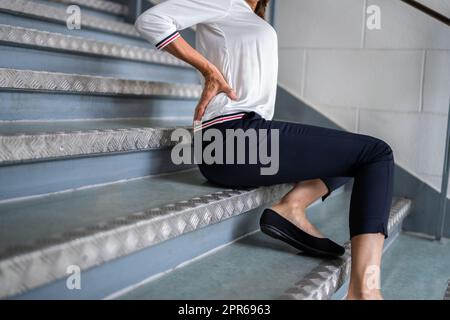 Donna matura che giace su Staircase Foto Stock