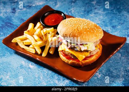 Hamburger. Succulenti cotolette di maiale, formaggio cheddar, cipolle croccanti sottaceto, lattuga avvolta in un panino sotto due salse. Servito con patatine fritte e salsa alla panna. Foto Stock