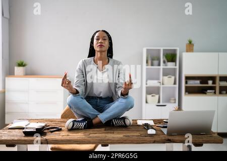 Dipendente africano che fa la salute mentale meditazione Yoga Foto Stock