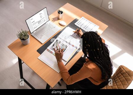 Donna d'affari che calcola l'imposta alla scrivania Foto Stock