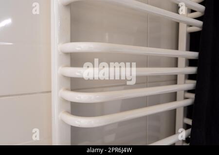 Scaletta bianca radiatore bagno e asciugamano scuro Foto Stock