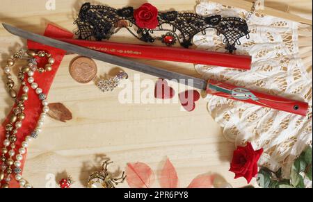 Ventilatore vintage in pizzo e fiore antico taglio spada dal Giappone con gioielli su tavola di legno Foto Stock