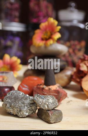 Cono incenso su lastra di pietra con cristalli e fiori Foto Stock