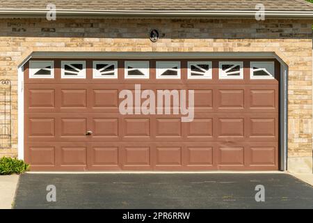 Porta del garage marrone con finestre bianche Foto Stock