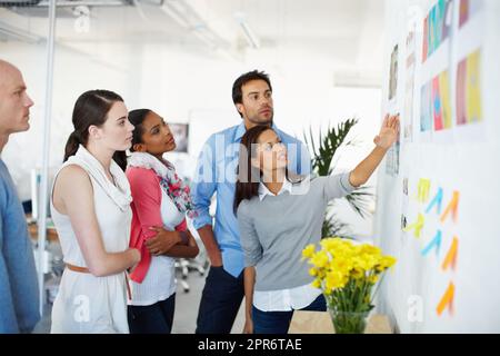 Theres non migliore lavoro che lavoro di squadra. Girato di un gruppo di uomini d'affari casualmente vestiti in ufficio. Foto Stock