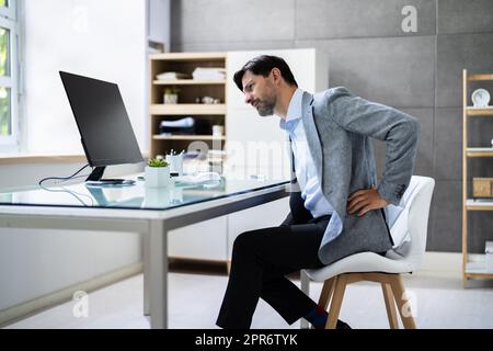 Cattiva postura seduta in ufficio con mal di schiena Foto Stock