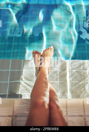 Gambe di lusso. Scatto corto di un piede di donna nell'acqua di una piscina termale. Foto Stock