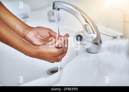 Germi e batteri giù lo scarico. Scatto corto di una donna che lava le mani ad un lavandino del bagno. Foto Stock