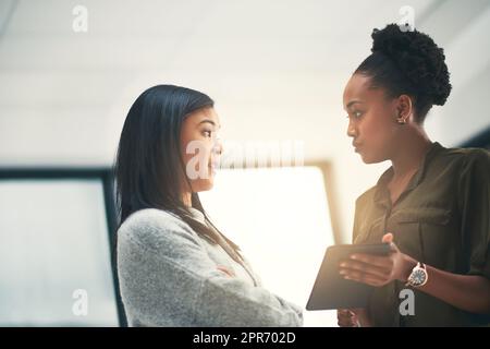 Erano di destra sul programma con il progetto finora. Scatto ritagliato di due giovani creativi che hanno una discussione in un ufficio. Foto Stock