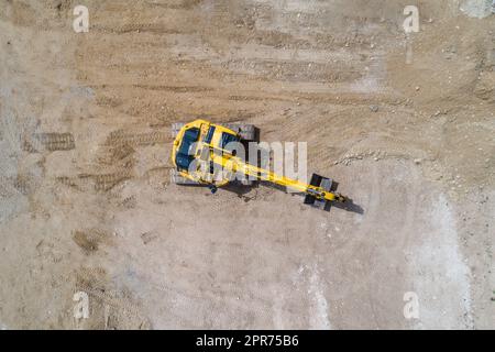 escavatore che lavora in un sito scavando il terreno Foto Stock