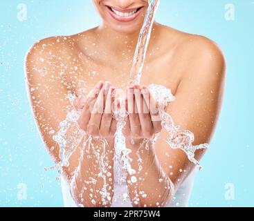 Bella pelle inizia qui. Studio shot di acqua che scorre in una donna mani. Foto Stock