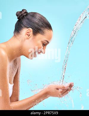 Inizia con la cura della pelle. Studio shot di acqua che scorre in una donna mani. Foto Stock