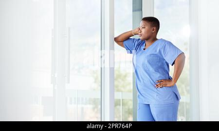 Attenzione costante da parte di un buon infermiere. Shot di un'infermiera femminile in cerca di stress mentre si trova in ospedale. Foto Stock