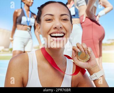 Ritratto in primo piano di una atletica di razza mista che mostra la medaglia d'oro della competizione in eventi sportivi. Un atleta latinoamericano attivo che si sente orgoglioso dopo aver vinto la gara di corsa. Foto Stock